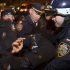 Four police officers restrain a protester.