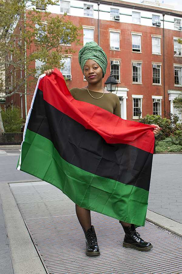  Chioma Nwana, president of NYU’s African Students Union, is wearing a traditional Nigerian headscarf and holding the Pan-African flag. 