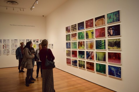 Museum visitors look at Egyptian photographer Basim Magdy’s collection of chromogenic color prints called “The Hollow Desire to Populate Imaginary Cities.”