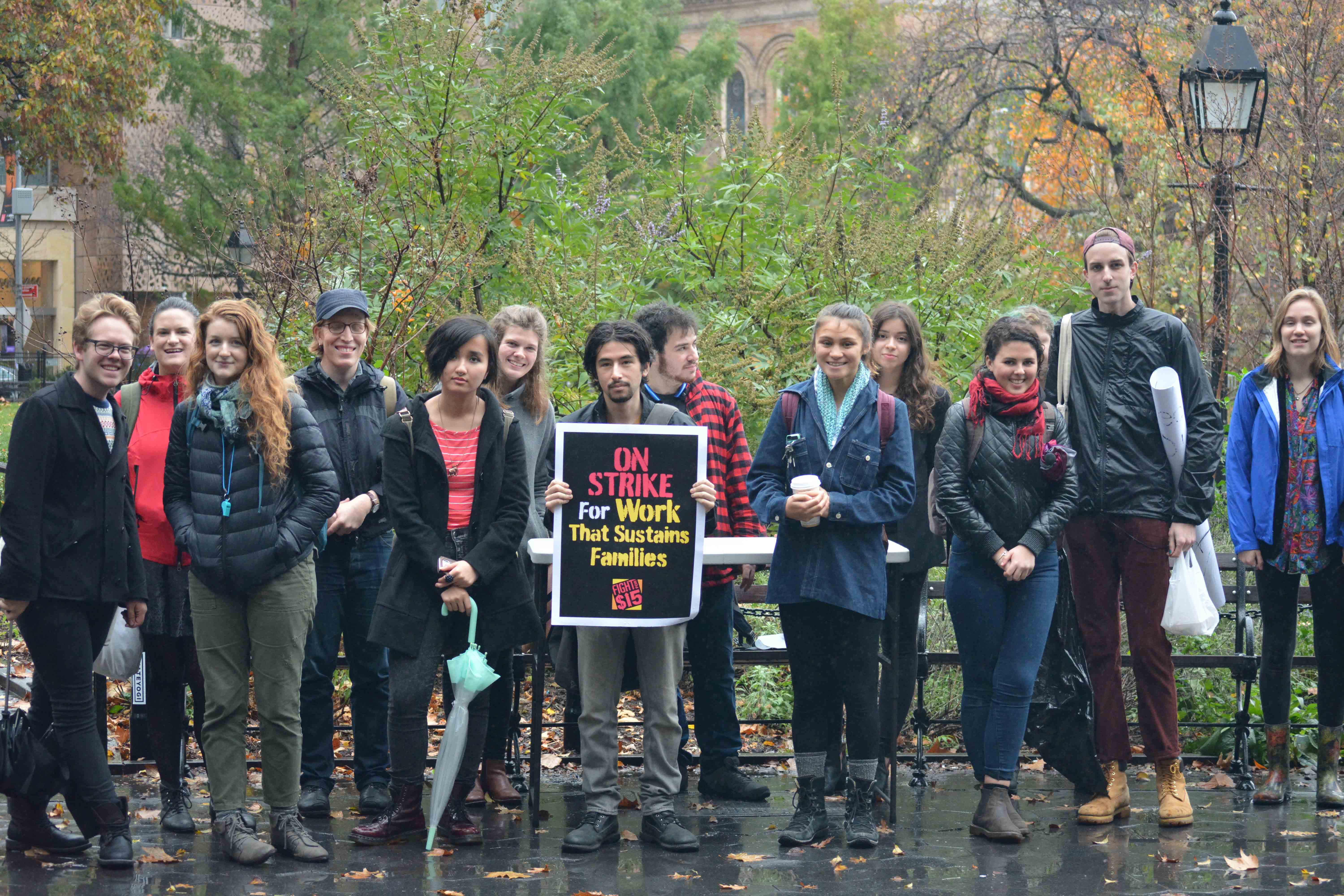 Braving the rain, students gather in Washington Square Park to protest wages provided by NYU for their student employees.