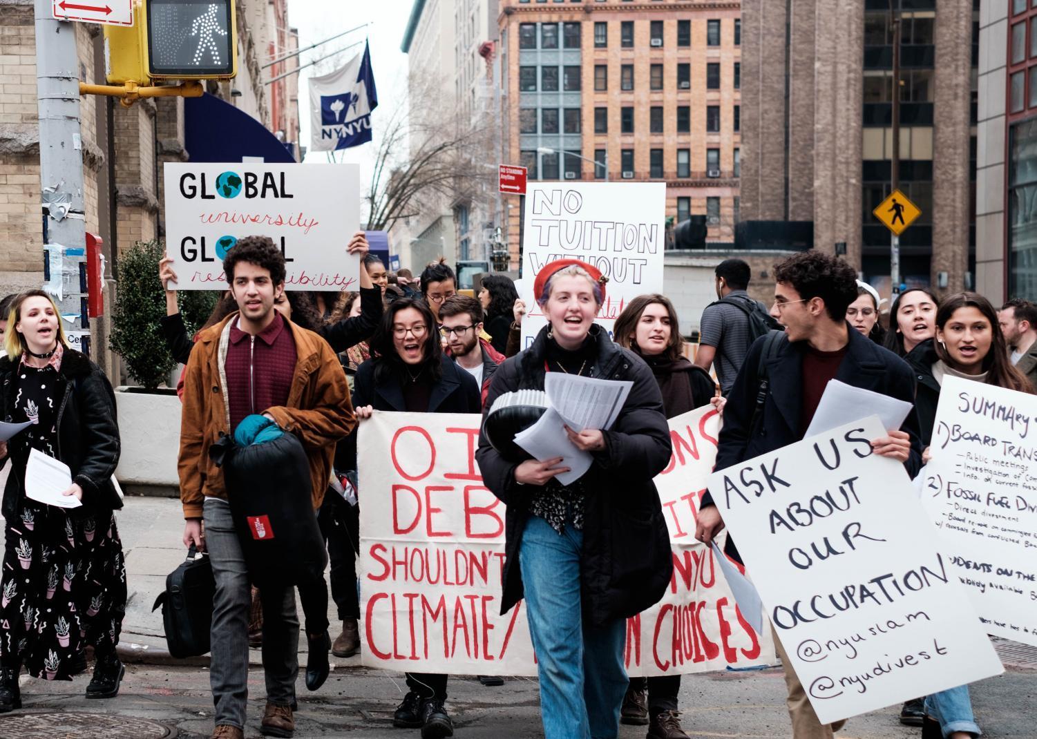 Demonstrators marching from the Admissions Center to the Kimmel Center for University Life yesterday, chanting and handing out flyers outlining their demands to passersby.
